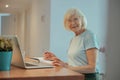 Portrait of joyful senior woman with laptop indoors Royalty Free Stock Photo
