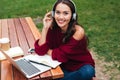Portrait of a joyful smart asian girl in headphones studying