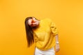 Portrait of joyful smiling funny young woman in fur sweater, white pants and heart orange eyeglasses isolated on bright