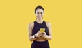 Portrait of joyful sportswoman who uses sports applications for her trainings on her mobile phone. Royalty Free Stock Photo