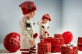 Portrait of adroable twin-elves among huge Christmas presents Royalty Free Stock Photo