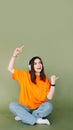 Portrait of a joyful woman wearing headphones, expressing enthusiasm and approval while pointing both thumbs towards