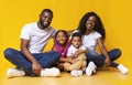 Portrait of joyful young afro family with two little kids