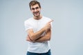 Portrait of a joyful young man pointing fingers away at copy space on his palm isolated over gray background. Royalty Free Stock Photo