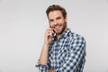 Portrait of joyful young man smiling and talking on cellphone Royalty Free Stock Photo