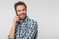 Portrait of joyful young man smiling and talking on cellphone Royalty Free Stock Photo