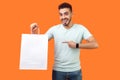 Portrait of joyous buyer, brunette man pointing at packages, shopping bags. indoor studio shot isolated on orange background