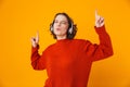 Portrait of joyous woman 20s wearing wireless headphones dancing and singing