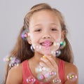 Portrait, kid and blowing bubbles in studio by toy, happiness and fun games for hand eye coordination. Little girl, face Royalty Free Stock Photo