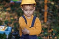 Portrait of kid boy builder wearing protective yellow helmet looking at camera. Little boy engineer builder architect Royalty Free Stock Photo