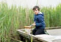 Portrait Kid boy catching creatures in pond with net in Spring time,  Child explorer and learning about wild nature in countryside Royalty Free Stock Photo