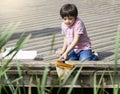 Portrait Kid boy catching creatures in pond with net in summer time,  Child explorer and learning about wild nature in countryside Royalty Free Stock Photo