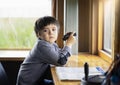 Portrait of kid boy child looking deep in throught holding binoculars in the animals station view point, A young explorer with Royalty Free Stock Photo