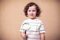 A portrait of kid boy holding magnifier. Children and knowlage concept Royalty Free Stock Photo