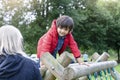 Portrait kid climbing on wooden fame in the park with blurry foreground of grandmother, Child enjoying activity in a climbing adve Royalty Free Stock Photo