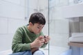 Portrait Kid clipping nails in the bathroom, Child boy Cutting toe nails with nail clippers, Children health and Hygiene care,