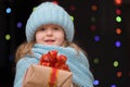 Portrait of a teenage girl with a gift in a winter blue knitted