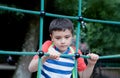 Portrait Kid holding robe in outdoors playground, Child climbing adventure park on sunny day Spring or sSmmer, Lonely young boy