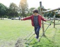 Portrait kid jumping off from wooden climbing frame in the park, Child enjoying activity in a climbing adventure park on summer Royalty Free Stock Photo