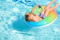 Portrait of a kid laughing in a swimming pool. Cocktail on watter pool in the summer. Royalty Free Stock Photo