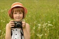 Portrait of a kid photographer a little girl with a camera on the background of nature. Royalty Free Stock Photo