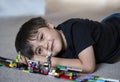 Portrait kid playing plastic blocks, Happy Child boy lying on carpet floor  bluiding his colouful blocks toys, Young boy with Royalty Free Stock Photo