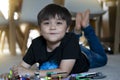 Portrait kid playing plastic blocks, Happy Child boy lying on carpet floor  bluiding his colouful blocks toys, Young boy with Royalty Free Stock Photo