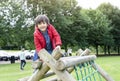 Portrait kid sitting on wooden climbing frame in the park, Child enjoying activity in a climbing adventure park on summer sunny da Royalty Free Stock Photo