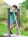 Portrait kid standing on wooden in the park, Child enjoying activity in a climbing adventure park on summer sunny day, little boy Royalty Free Stock Photo