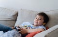 Portrait kid wearing earphones and playing video game. Child holding console play game online with friends at home, Young boy Royalty Free Stock Photo