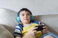 Portrait kid wearing headphones and playing video game. Child holding console play game online with friends at home, Young boy Royalty Free Stock Photo