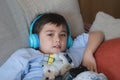 Portrait kid wearing headphones and playing video game. Child holding console play game online with friends at home, Young boy Royalty Free Stock Photo