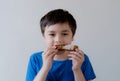 Portrait Kid with yummy face enjoy eating roasted chicken drumstick in the garden, Happy of cute boy eating grilled chicken,