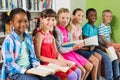 Portrait of kids reading book in library