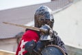 Portrait of knight in helmet with sword in hand_