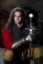 Portrait of Knight With Sword Sitting Against Stonewall and Looking Away Royalty Free Stock Photo