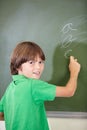 Portrait, knowledge and boy drawing on a chalkboard for child development, creativity and art for learning. Academic Royalty Free Stock Photo