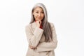 Portrait of korean businesswoman, woman with grey hair thinking, wearing suit, smiling intrigued, standing over white Royalty Free Stock Photo