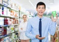 Portrait of korean man client who is satisfied of recommended medicines in pharmacy.