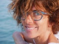Portrait lady with blue eyes and glasses at sea. Smiling woman on cruise vacation, real people traveling, outdoors natural