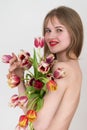 Portrait lady feeling excited to receive bunch of tulips for Woman& x27;s Day covering chest with flowers
