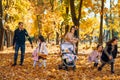 portrait of a large family with children in an autumn city park, happy people walking together, playing and throwing yellow leaves Royalty Free Stock Photo