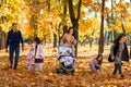 portrait of a large family with children in an autumn city park, happy people walking together, playing and throwing yellow leaves Royalty Free Stock Photo