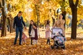 portrait of a large family with children in an autumn city park, happy people walking together, playing and throwing yellow leaves Royalty Free Stock Photo