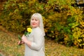 Portrait of a large girl who stands and holds a yellow rose in her hand, looking at the camera and posing on a Sunny Royalty Free Stock Photo
