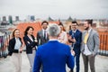 A group of joyful businesspeople having a party outdoors on roof terrace in city.