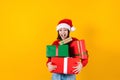 Portrait of Latin child girl holding Christmas gift box on a yellow background in Mexico latin america Royalty Free Stock Photo