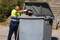 Portrait of latin garbage man throwing garbage into dumpster in work clothes Royalty Free Stock Photo