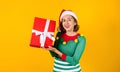 Portrait of Latin teenager girl holding Christmas gift box on a yellow background in Mexico latin america Royalty Free Stock Photo