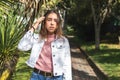 Portrait of a Latina teenage girl with straight hair and braces wearing a pink blouse looking at camera outdoors Royalty Free Stock Photo